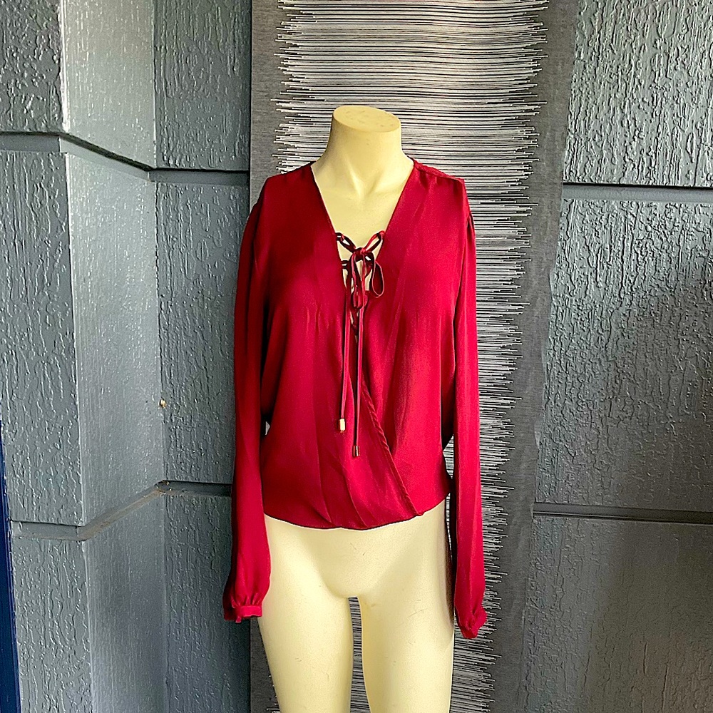 A beautiful wine red blouse with lace up detail on the front.